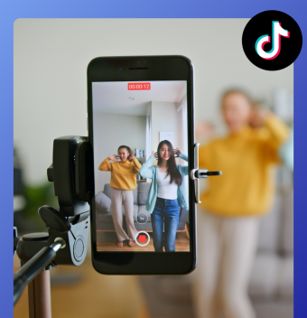 smartphone accroché sur un trépied qui filme deux filles en train de faire un tiktok